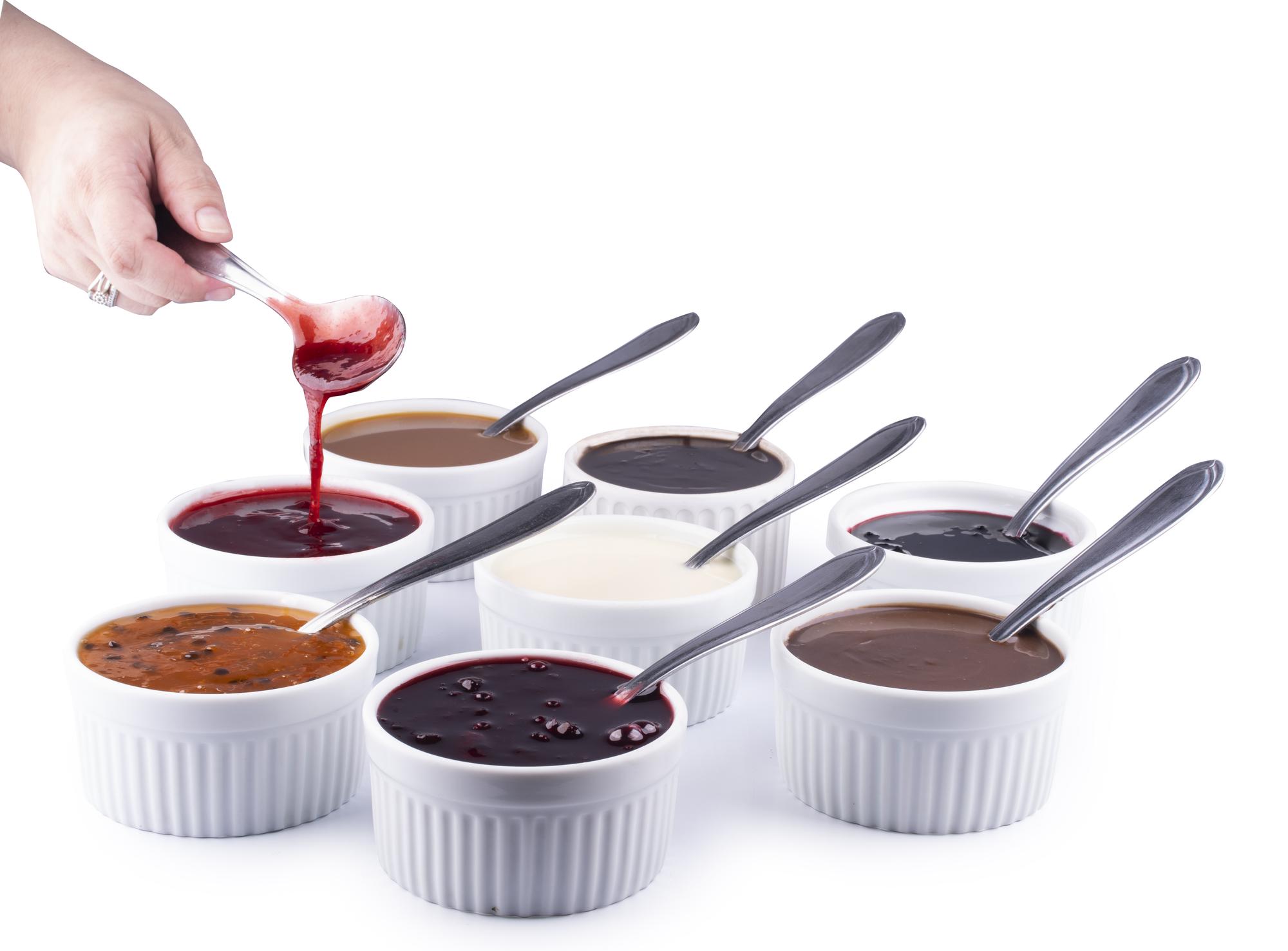 Workshop chef tasting sauce in bright kitchen